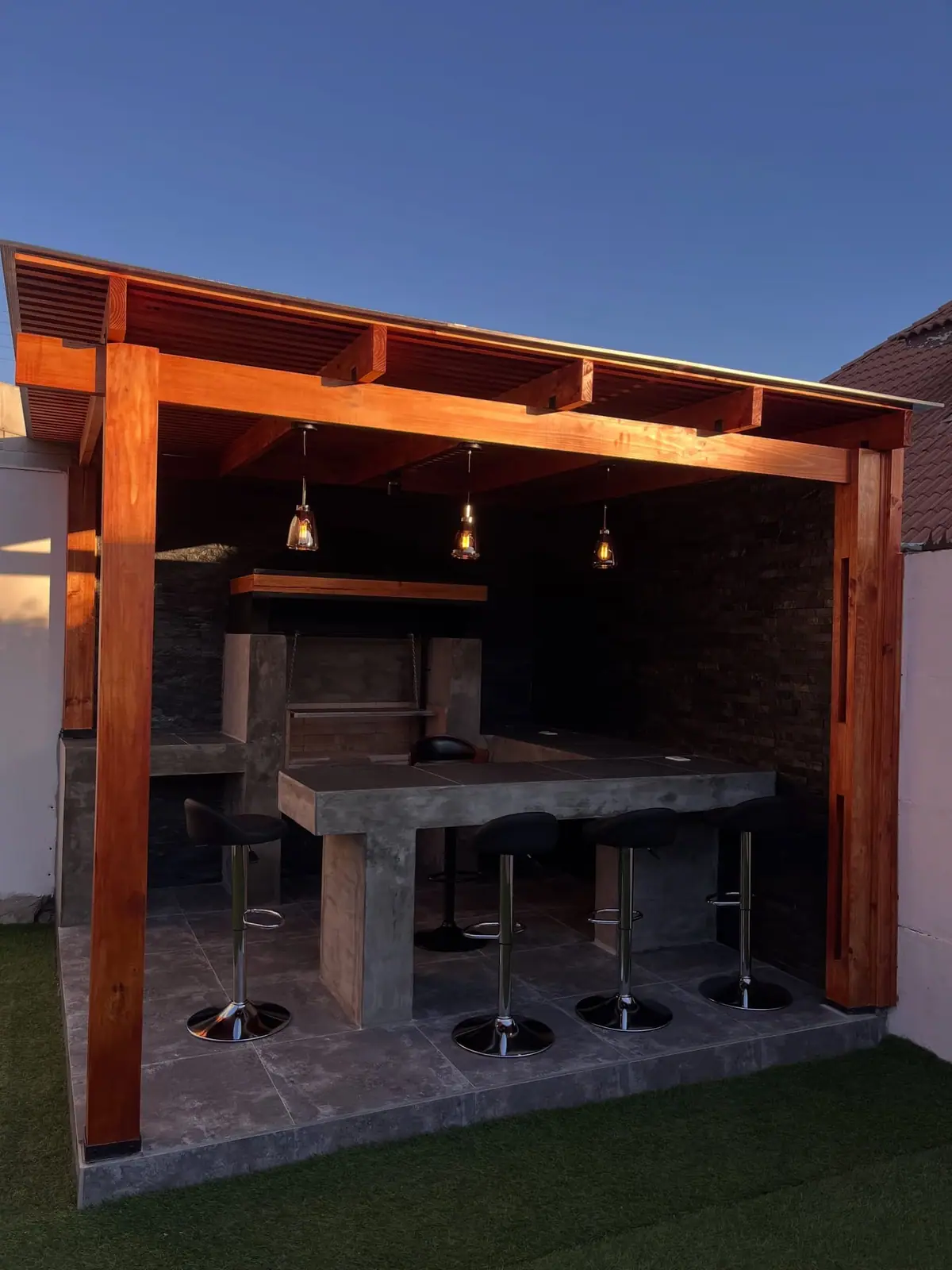 Quincho de madera con barra y parrilla revestidos en piedra construido por GADB en La Serena